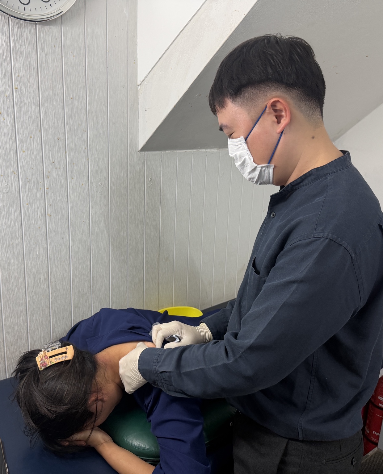 คุณหมอกำลังทำหัตถการฝังเข็มบริเวณกล้ามเนื้อ